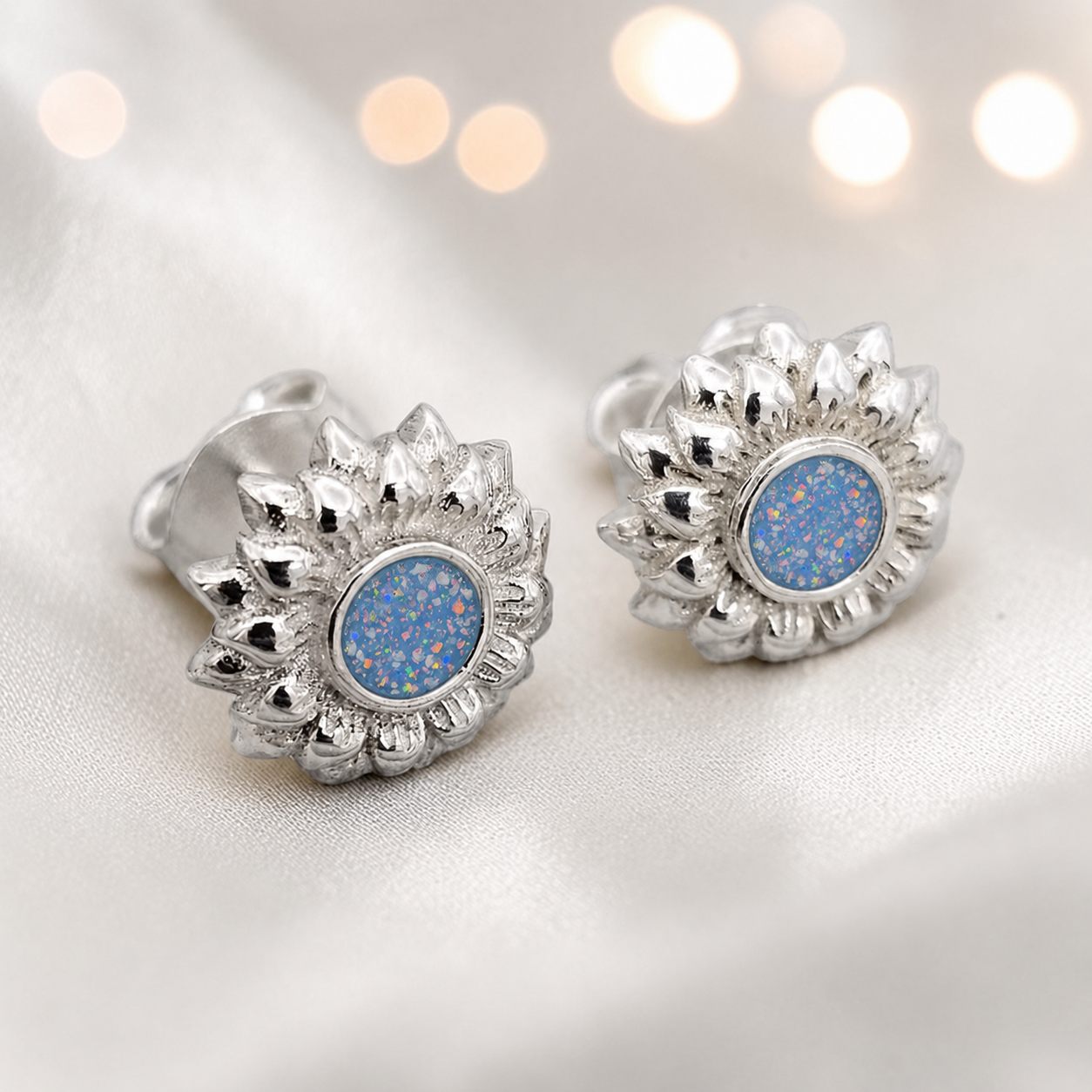Flora Earrings β silver sunflower ashes memorial stud earrings in Baby Blue resin, handcrafted in Lancashire, UK