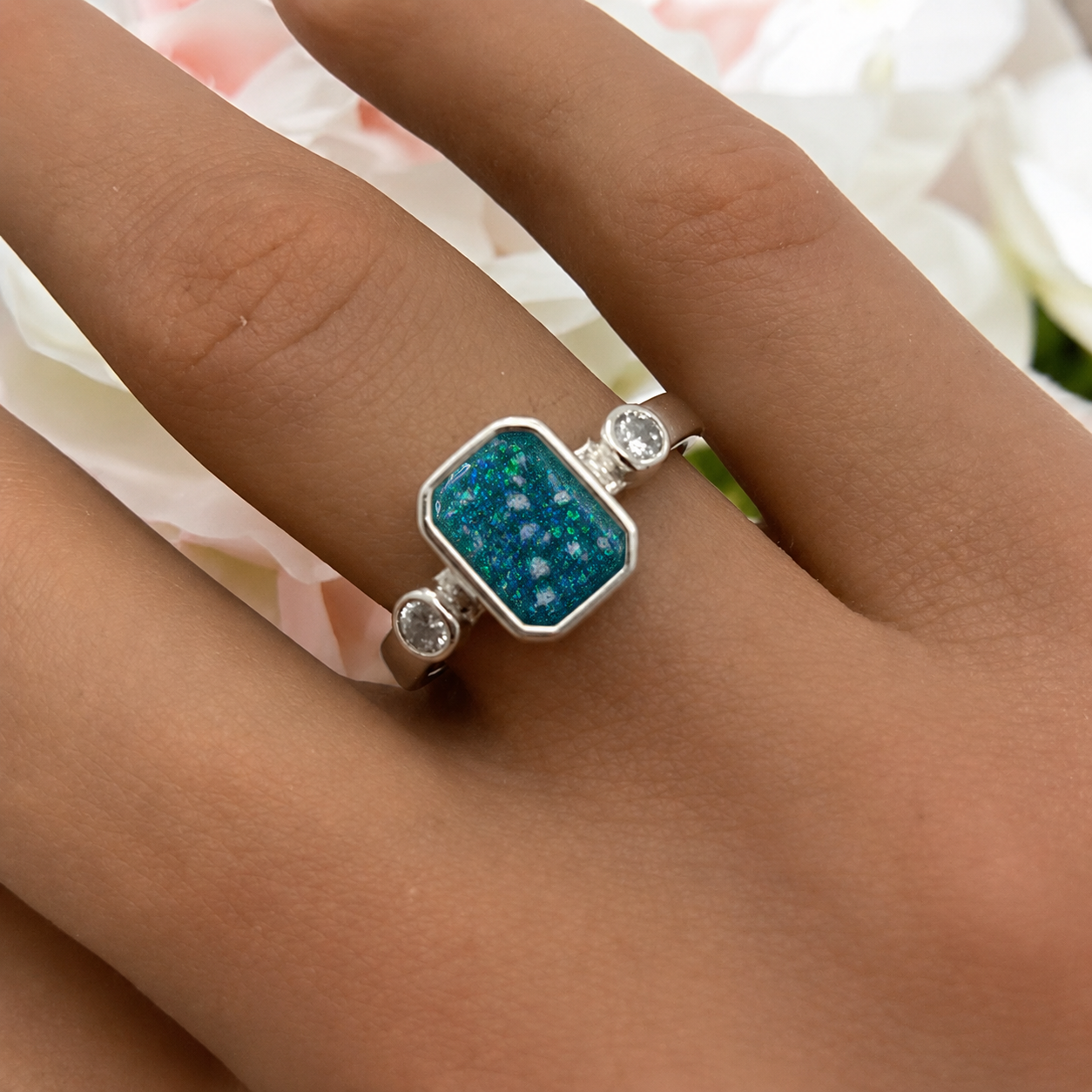 Keepsake Memorial Silver Anastasia Emerald Cut Ashes Ring in Teal Mist on hand — handcrafted in Lancashire, UK