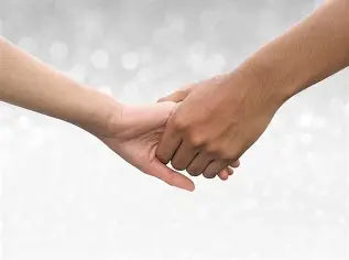 Two pairs of hands gently held together in comfort, representing support during grief
