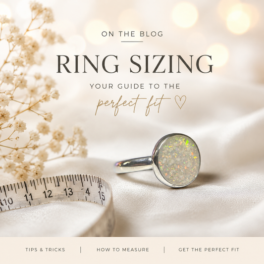 flat lay of ring sizing tools including a ring sizer and measuring tape, alongside a sterling silver memorial ring on a soft neutral background