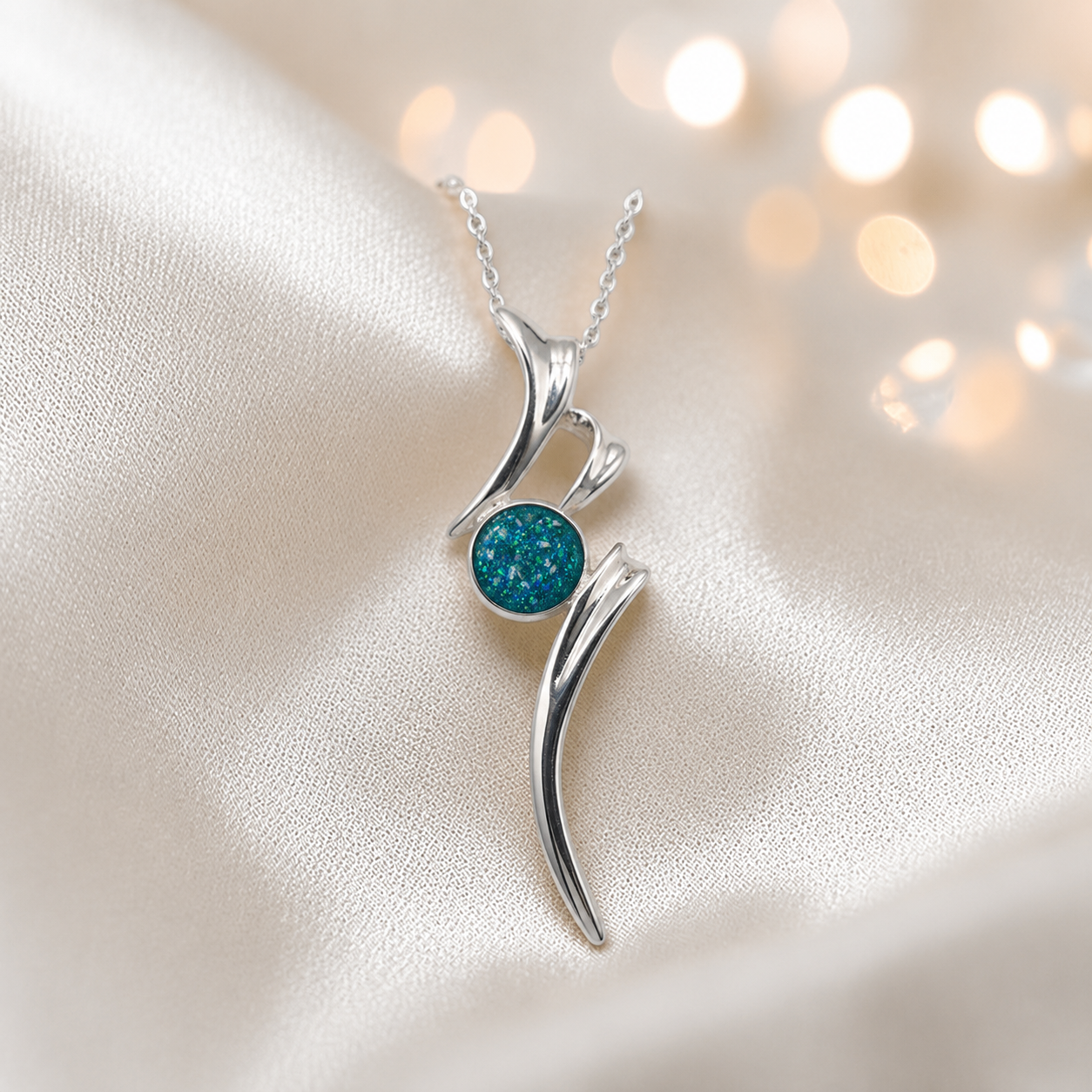 Abstract silver memorial ashes pendant in teal mist, handcrafted in Lancashire UK