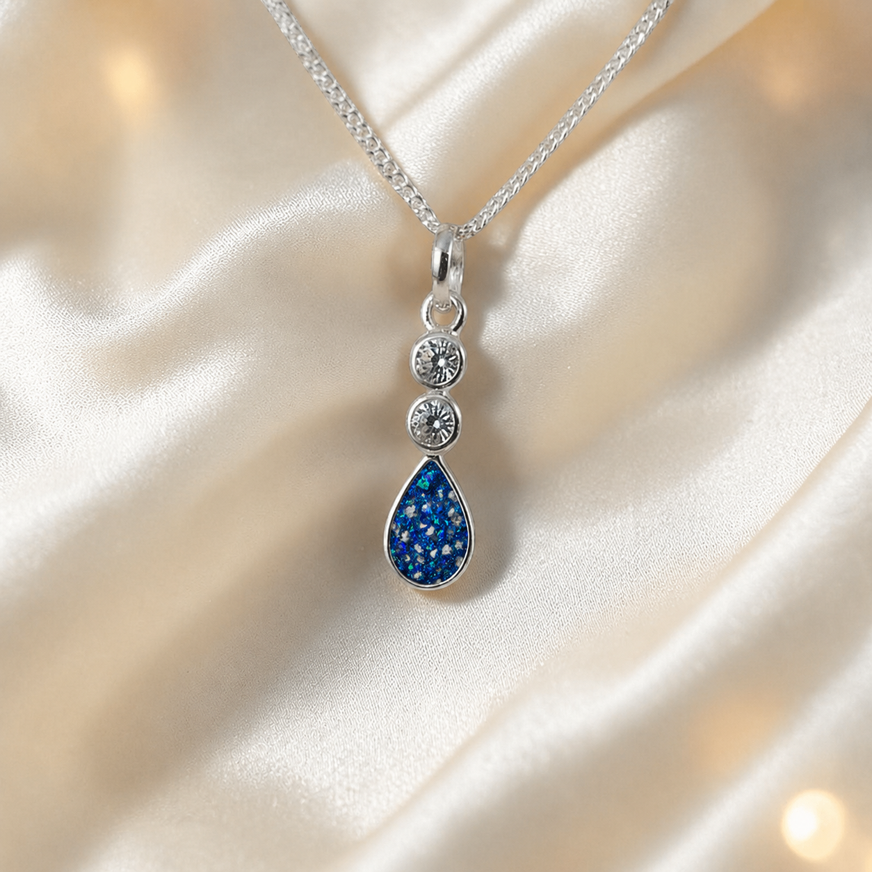 Acrux small tear drop CZ ashes pendant in sapphire glow, handcrafted in Lancashire UK