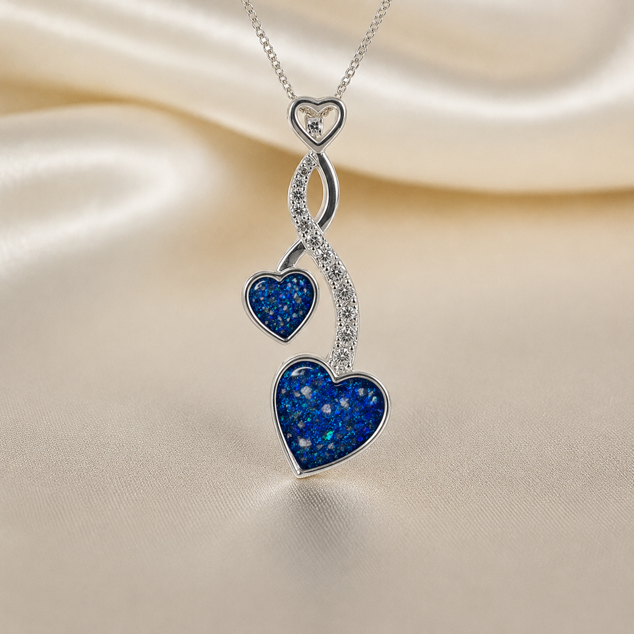 Aldera silver twin heart ashes memorial pendant in sapphire glow, handcrafted in Lancashire UK