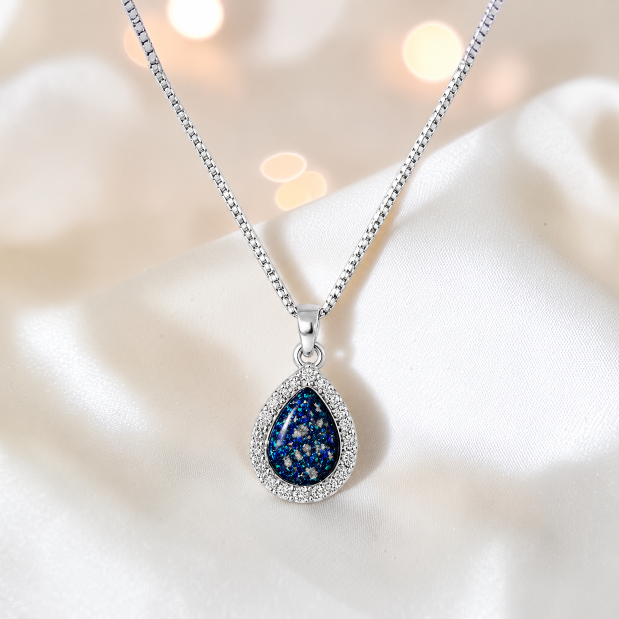 Almara teardrop dainty CZ ashes pendant in sapphire glow, handcrafted in Lancashire UK - by Keepsake Memorial Jewellery