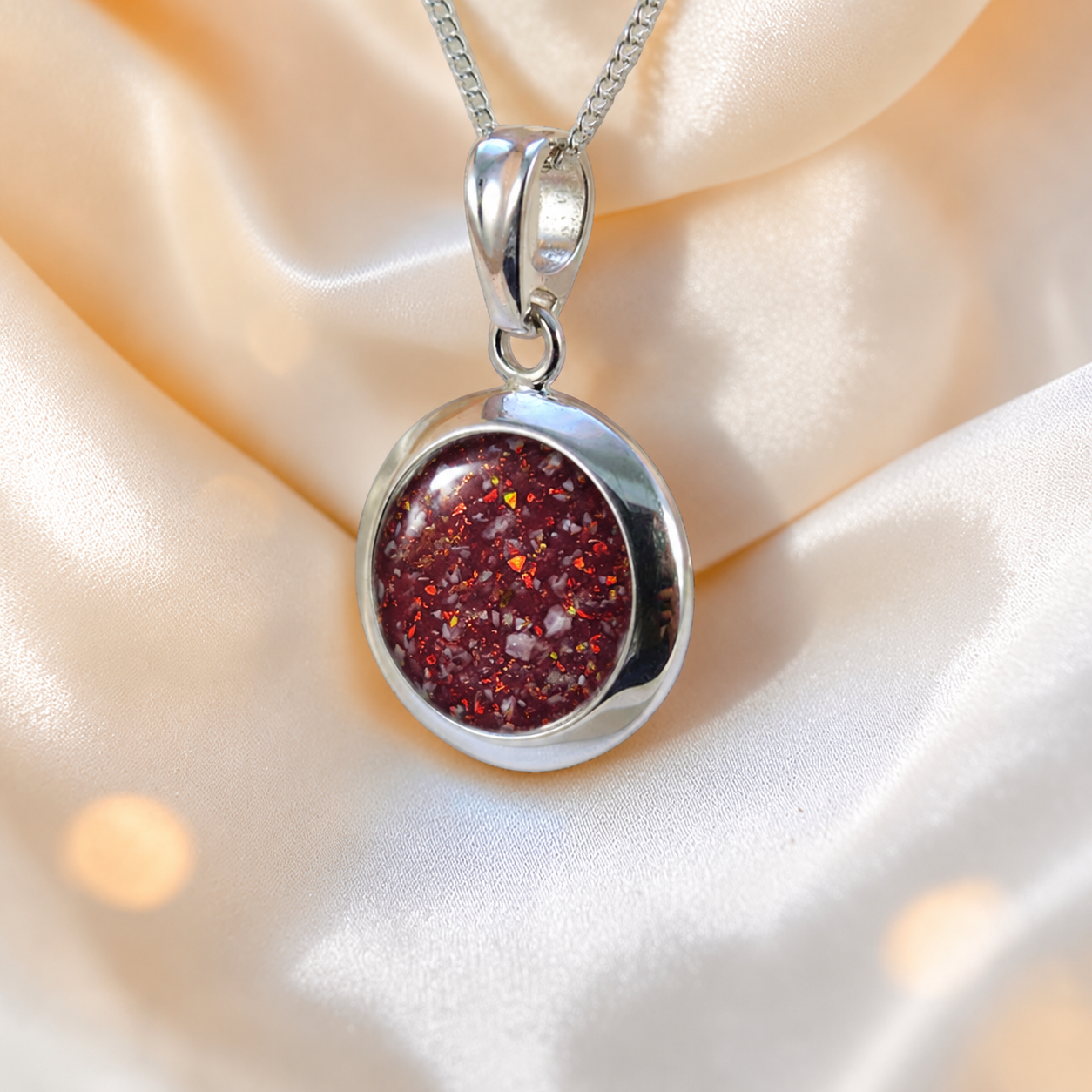 Altair round ashes pendant in ruby red, handcrafted in Lancashire UK