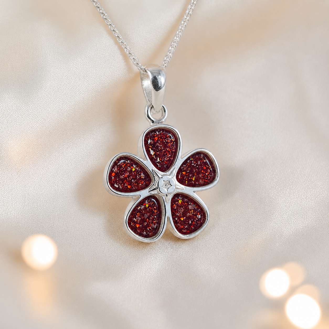 Arctura flower shaped ashes pendant in ruby red, handcrafted in Lancashire UK
