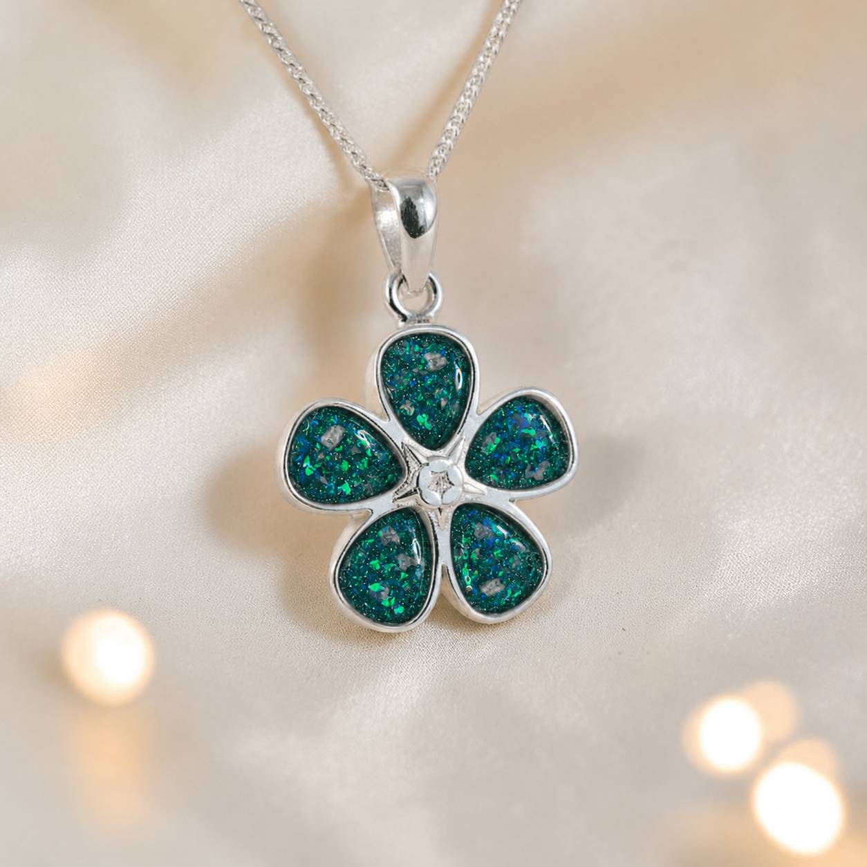Arctura flower shaped ashes pendant in teal mist, handcrafted in Lancashire UK