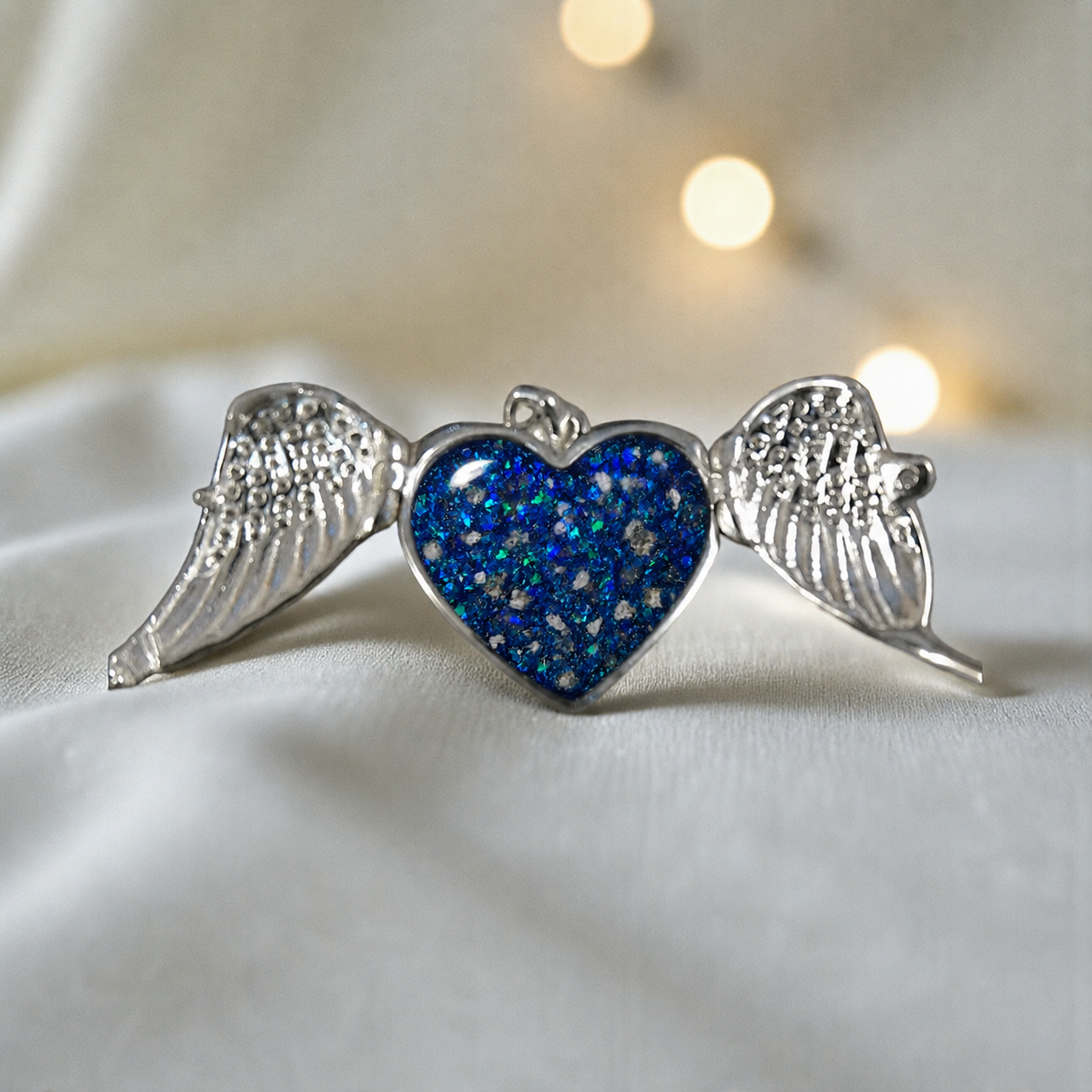Canopus angel wing memorial pendant in sapphire glow, handcrafted in Lancashire UK - by Keepsake Memorial Jewellery