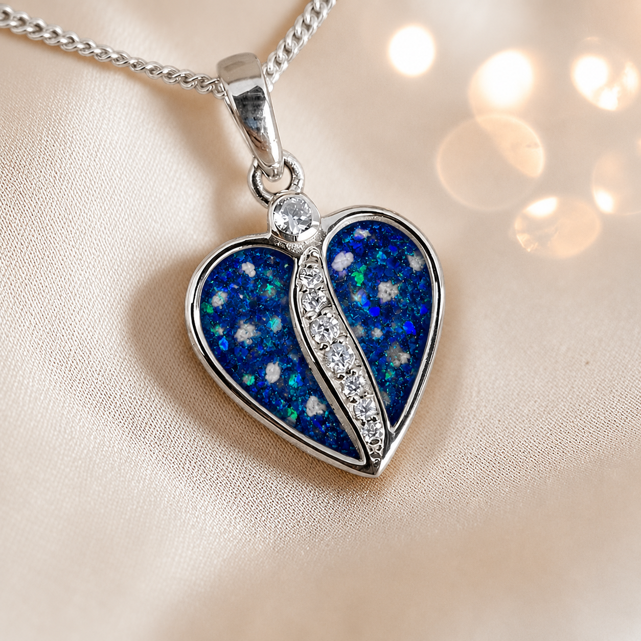 Elara Split heart shaped ashes pendant with CZ in sapphire glow, handcrafted in Lancashire UK
