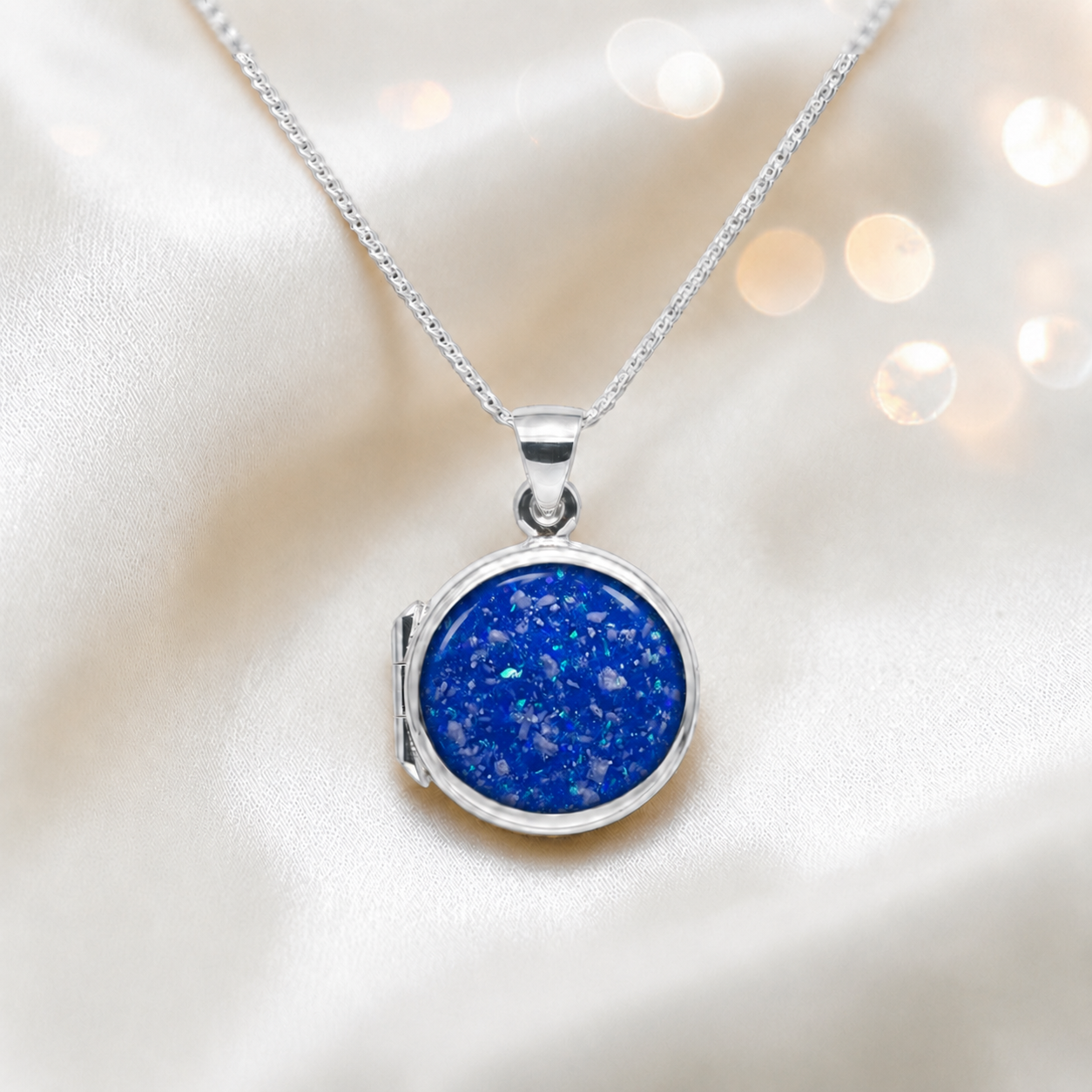 Electra round memorial locket in sterling silver, shown here in royal blue, handcrafted in Lancashire UK - by Keepsake Memorial Jewellery