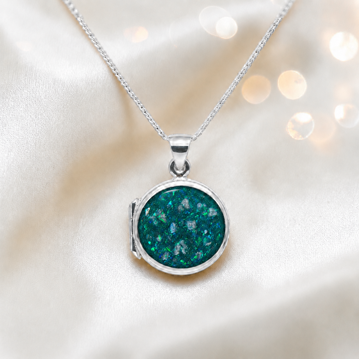 Electra round memorial locket in sterling silver, shown here in teal mist, handcrafted in Lancashire UK - by Keepsake Memorial Jewellery