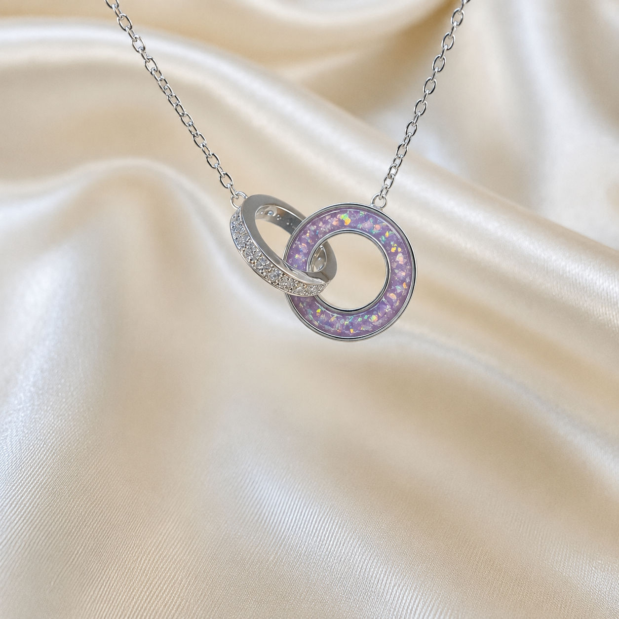 Eternal Embrace Pendant in 925 sterling silver — two interlocking rings with cubic zirconia in unicorn purple. Handcrafted memorial jewellery, made in Lancashire Uk -by Keepsake Memorial Jewellery
