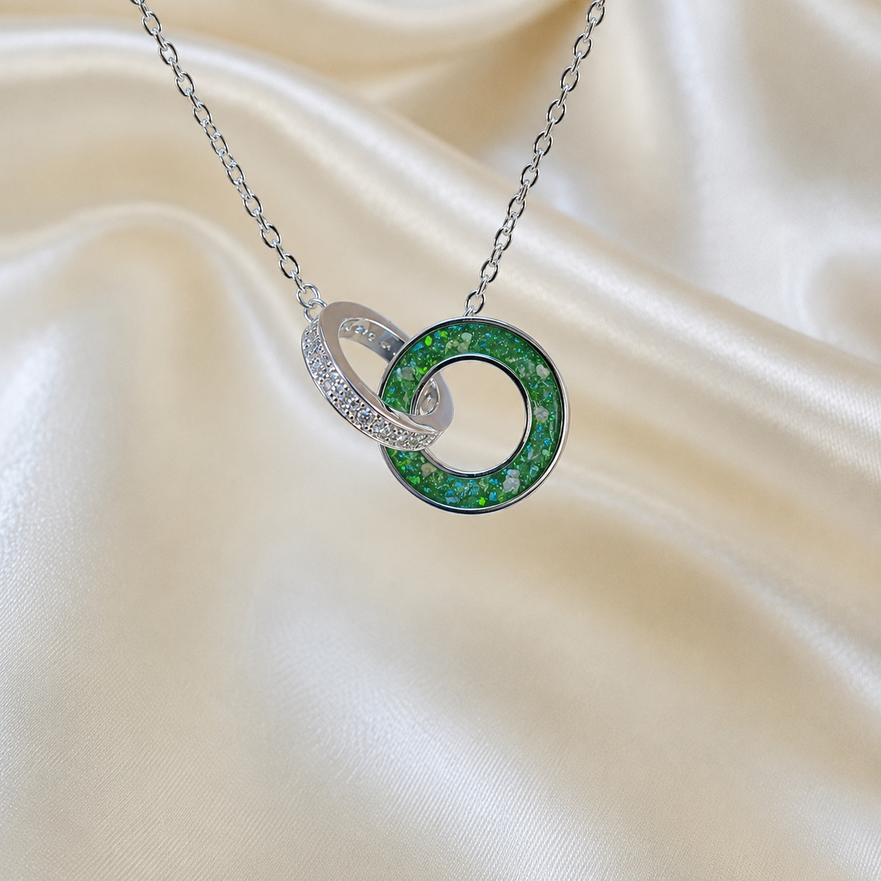 Eternal Embrace Pendant in 925 sterling silver — two interlocking rings with cubic zirconia in fruit green. Handcrafted memorial jewellery, made in Lancashire Uk -by Keepsake Memorial Jewellery