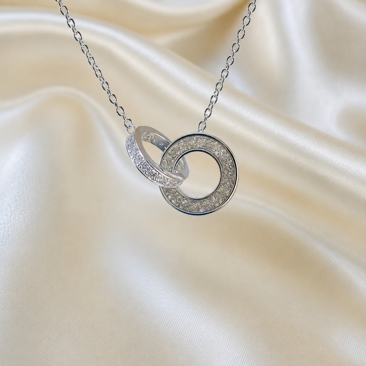 Eternal Embrace Pendant in 925 sterling silver — two interlocking rings with cubic zirconia in natural ash. Handcrafted memorial jewellery, made in Lancashire Uk -by Keepsake Memorial Jewellery