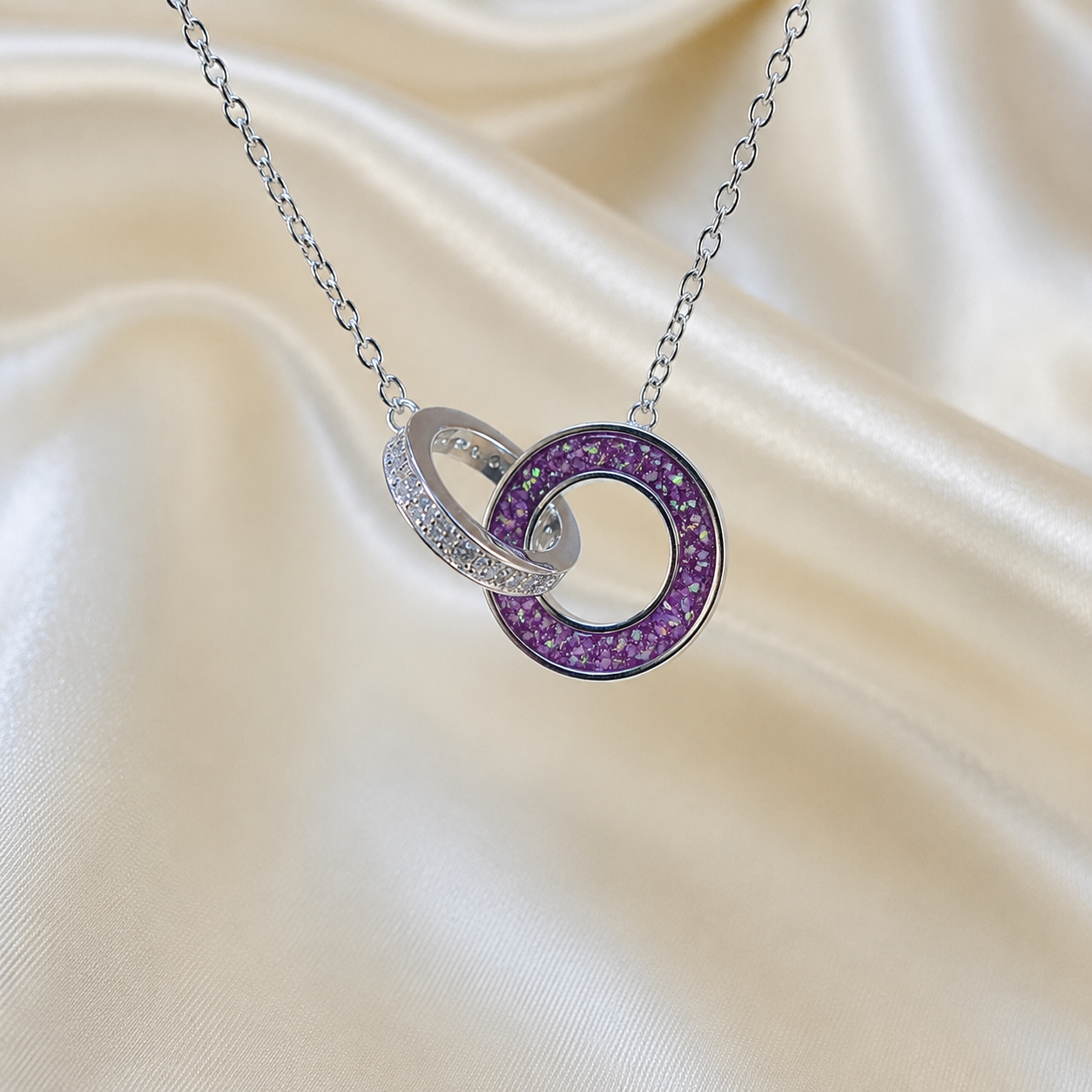 Eternal Embrace Pendant in 925 sterling silver — two interlocking rings with cubic zirconia in rose pink. Handcrafted memorial jewellery, made in Lancashire Uk -by Keepsake Memorial Jewellery