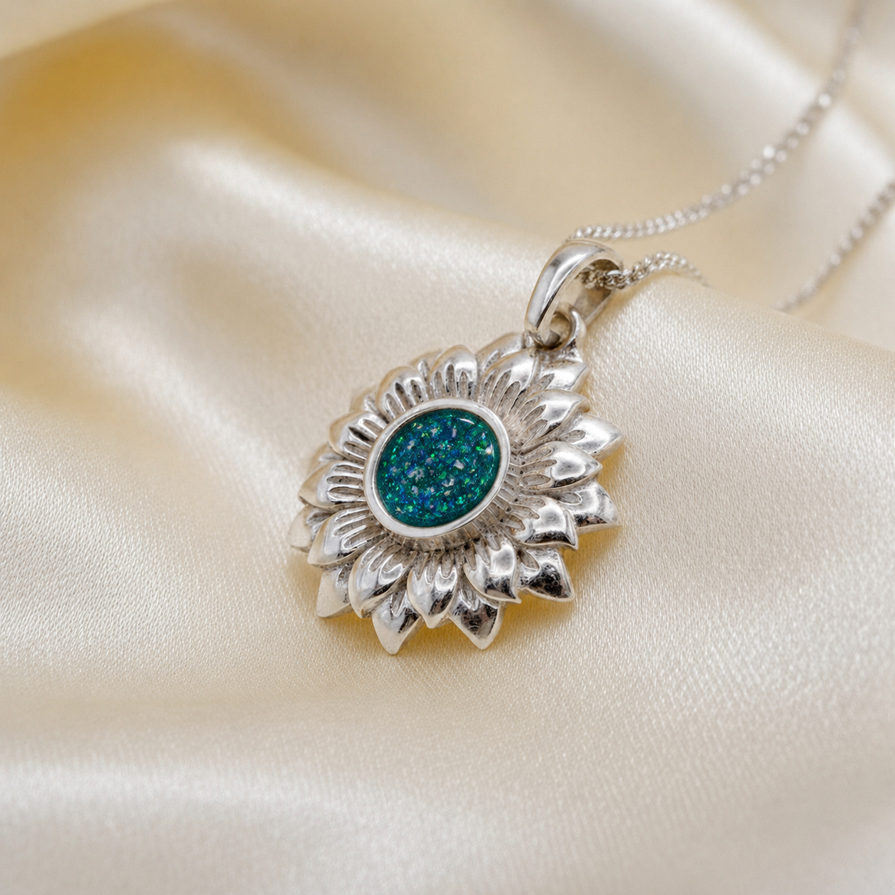 Flora sunflower silver ashes pendant in teal mist, handcrafted in Lancashire UK