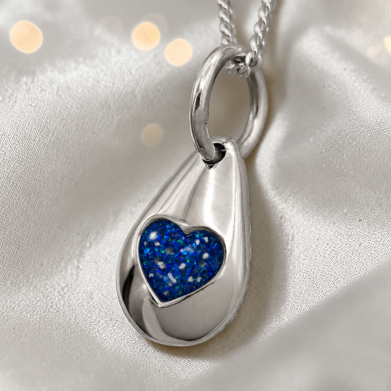 Gacrux pebble shaped pendant with heart memorial stone in sapphire glow, handcrafted in Lancashire UK - by Keepsake Memorial Jewellery