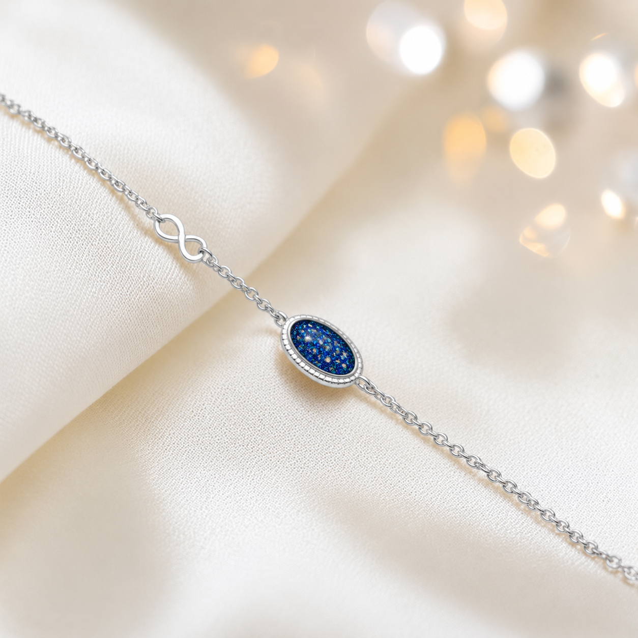 Lumen Bracelet — silver oval infinity ashes memorial bracelet in sapphire glow, handcrafted in Lancashire, UK - by Keepsake Memorial Jewellery
