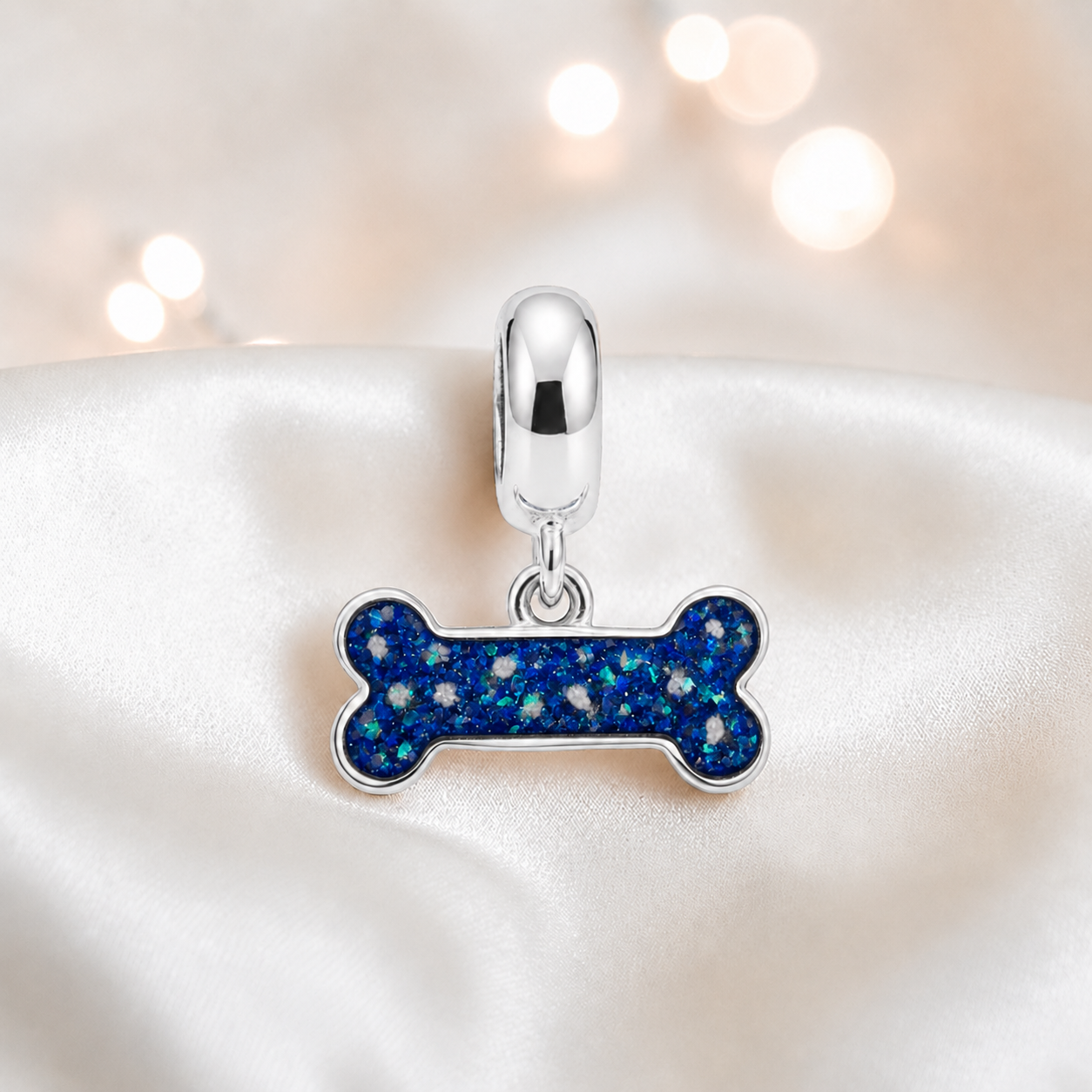Milo silver dog bone ashes charm, in sapphire glow, handcrafted in Lancashire UK - by Keepsake Memorial Jewellery 