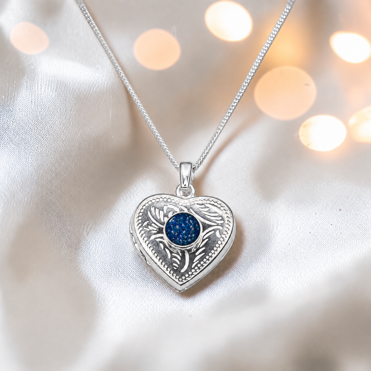 Rasal heart locket with round memorial stone in sapphire glow, handcrafted in Lancashire UK - by Keepsake Memorial Jewellery