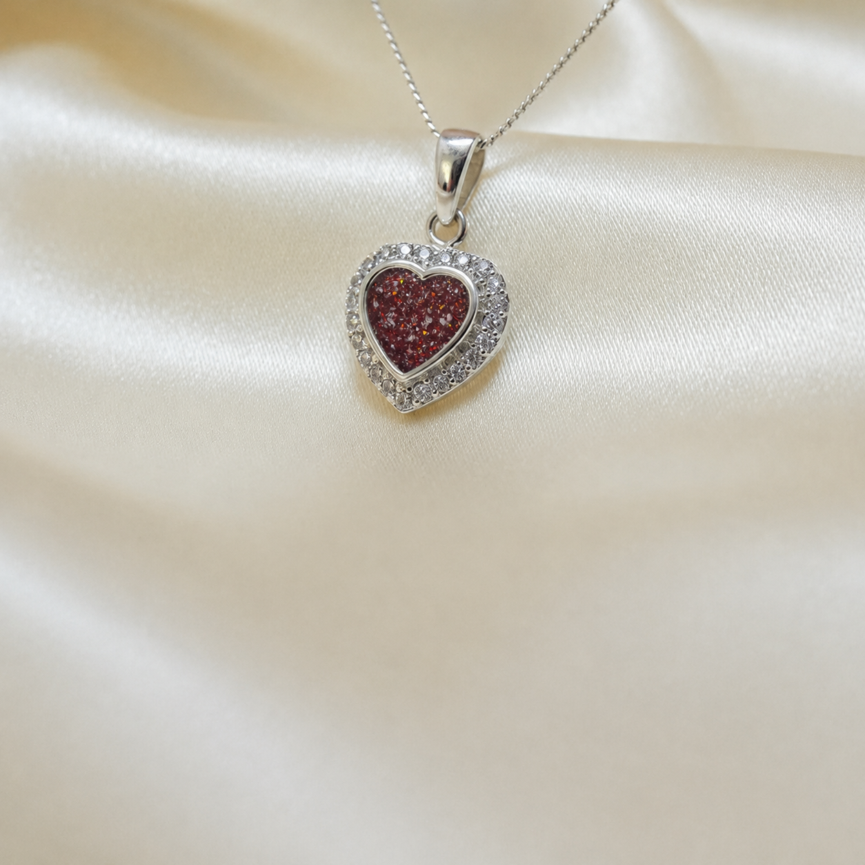 Rigel sterling silver heart ashes pendant with CZ stones, in ruby red, handcrafted in Lancashire UK 