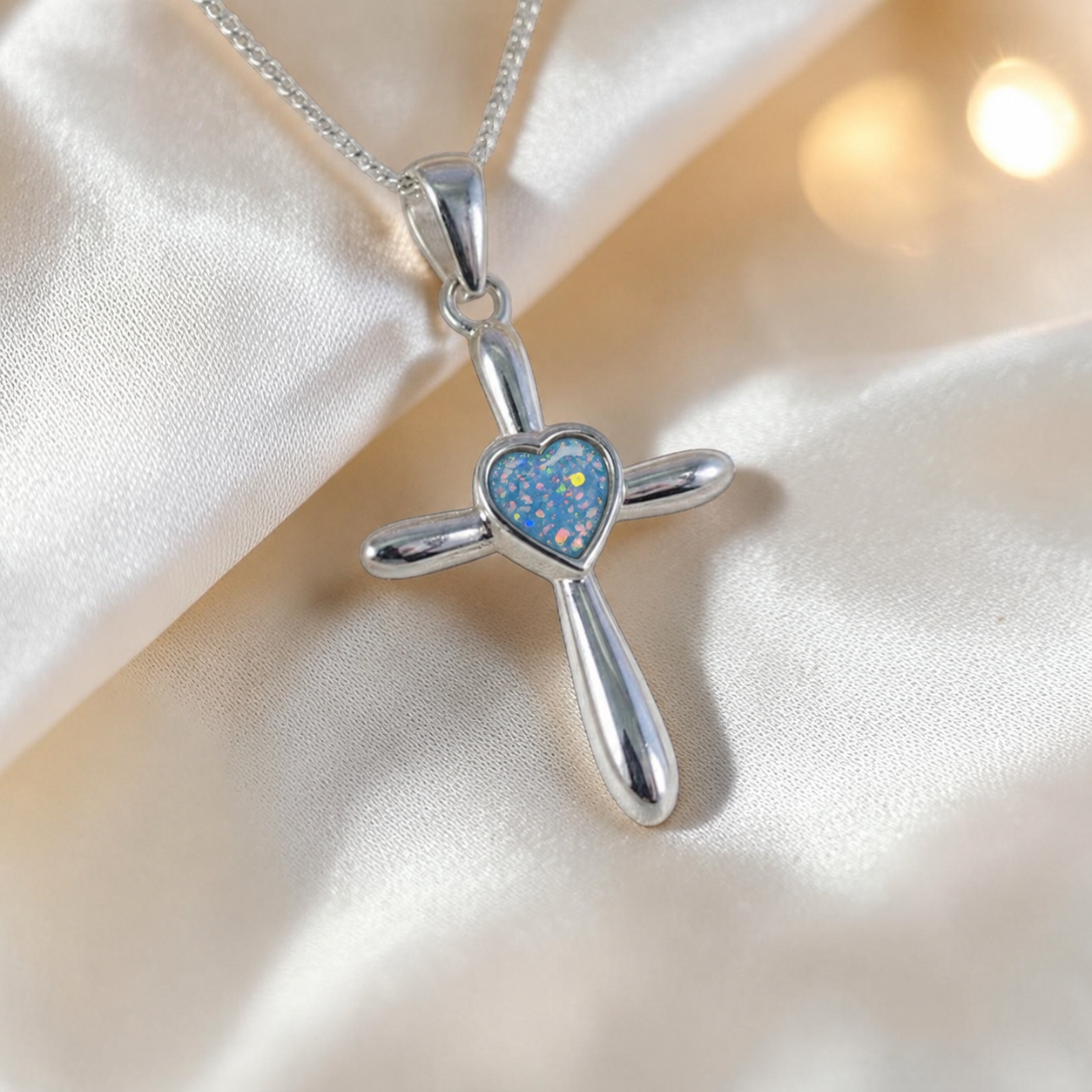 Saiph dainty sterling silver ashes cross with heart detail in baby blue, handcrafted in Lancashire UK - by Keepsake Memorial Jewellery  