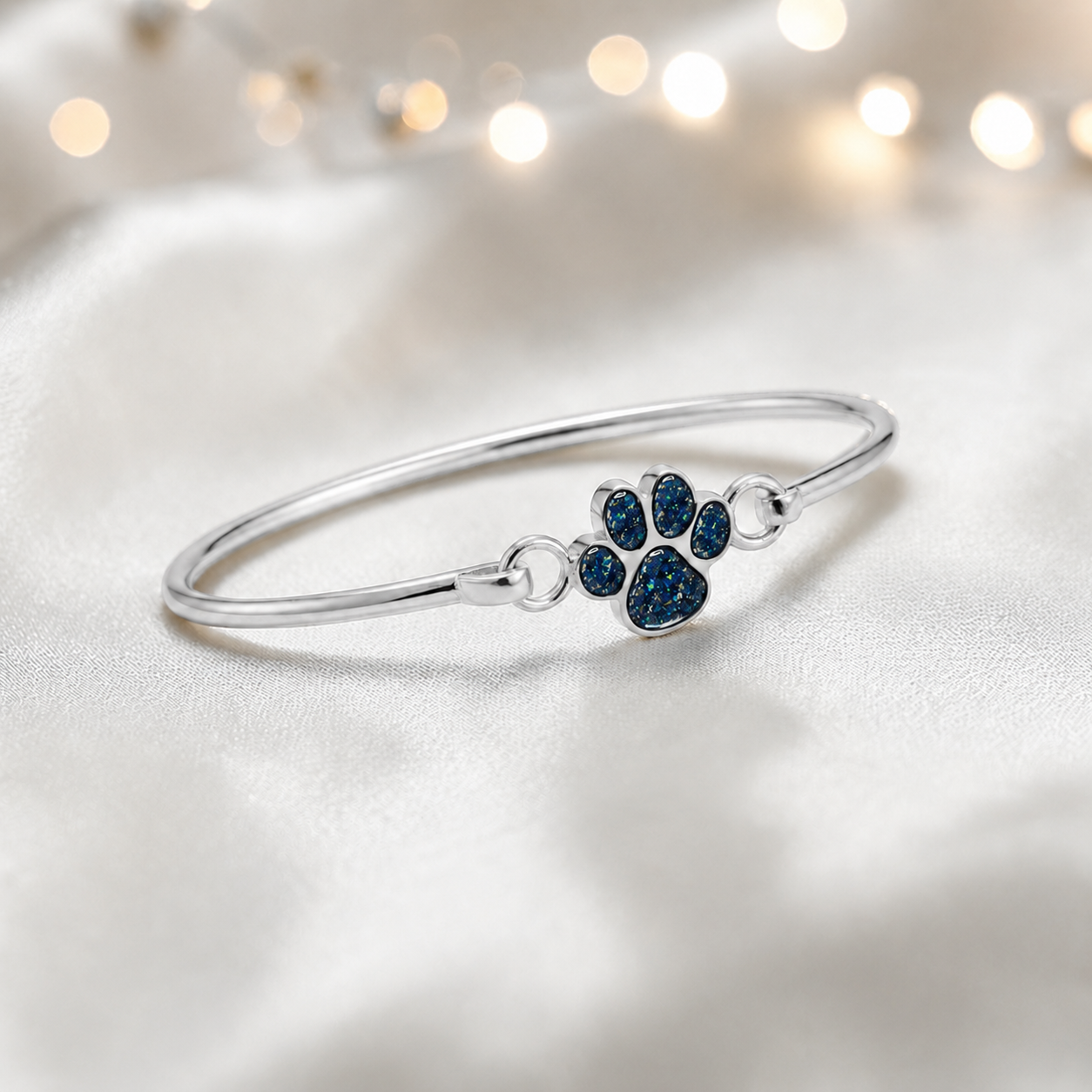 Starlight paw ashes bangle, in sapphire glow, handcrafted in Lancashire UK - by Keepsake Memorial Jewellery
