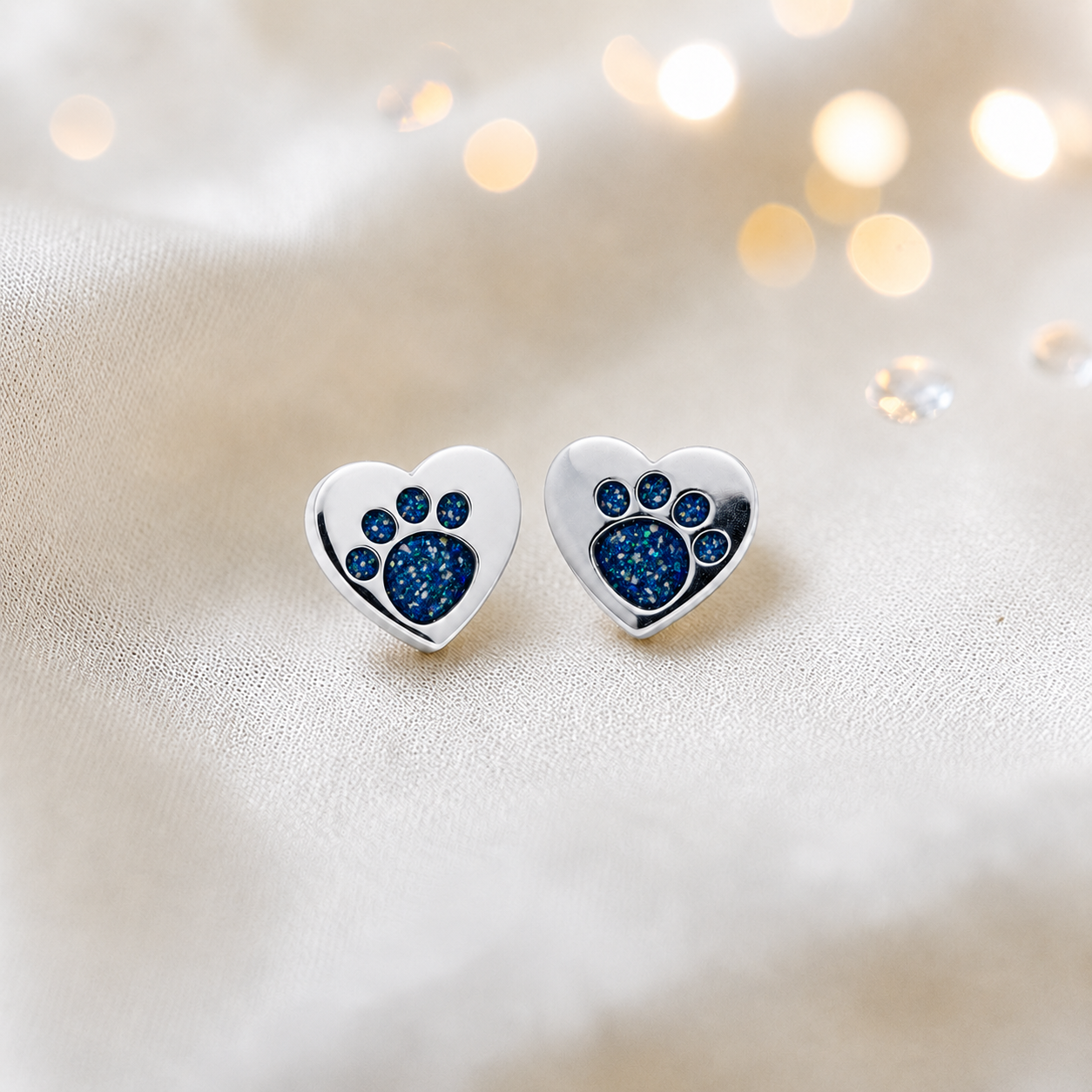 Tilly paw studs — silver heart shaped ashes memorial ear studs in sapphire glow, handcrafted in Lancashire, UK - by Keepsake Memorial Jewellery