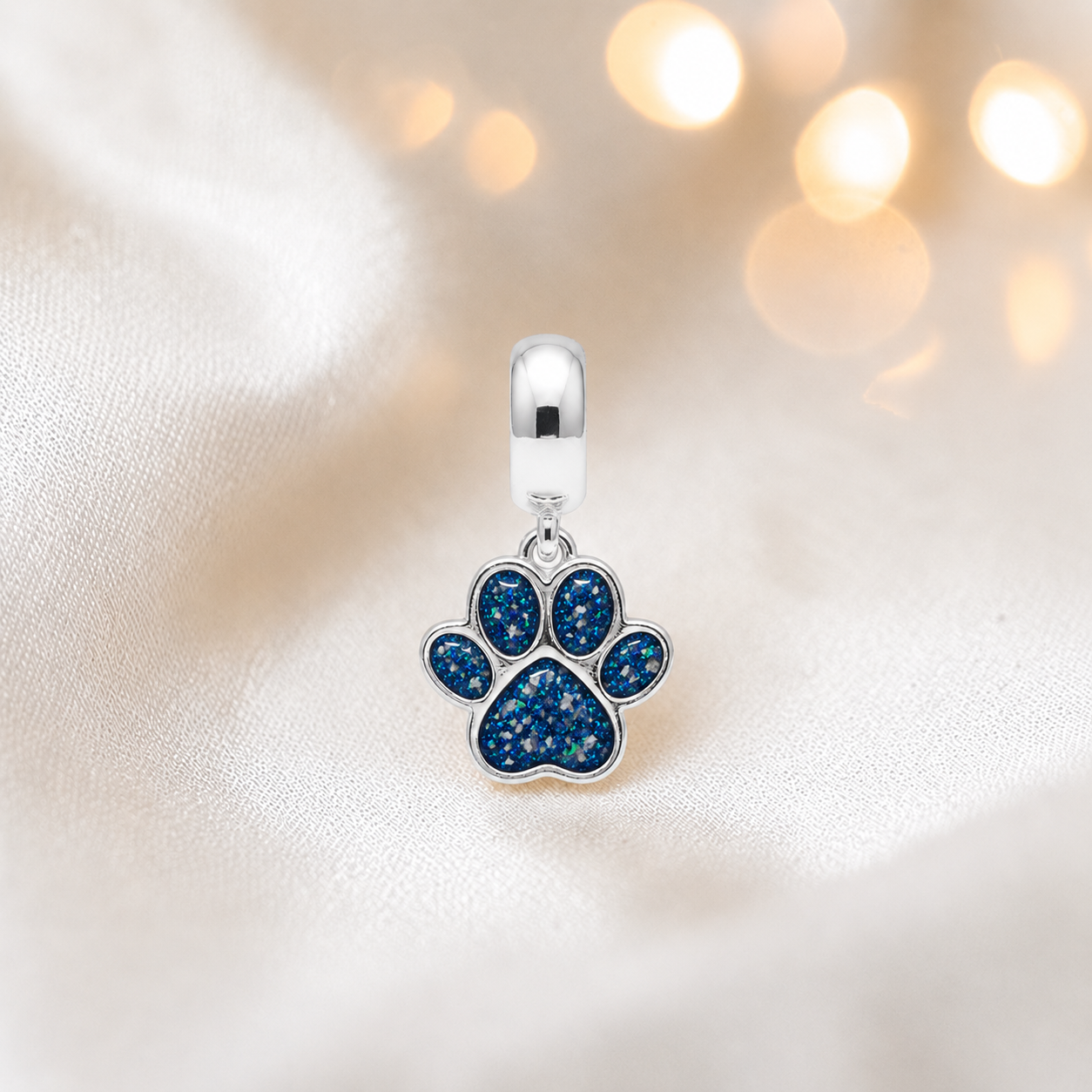 Whiskers dangle paw ashes charm, in sapphire glow, handcrafted in Lancashire UK - by Keepsake Memorial Jewellery 