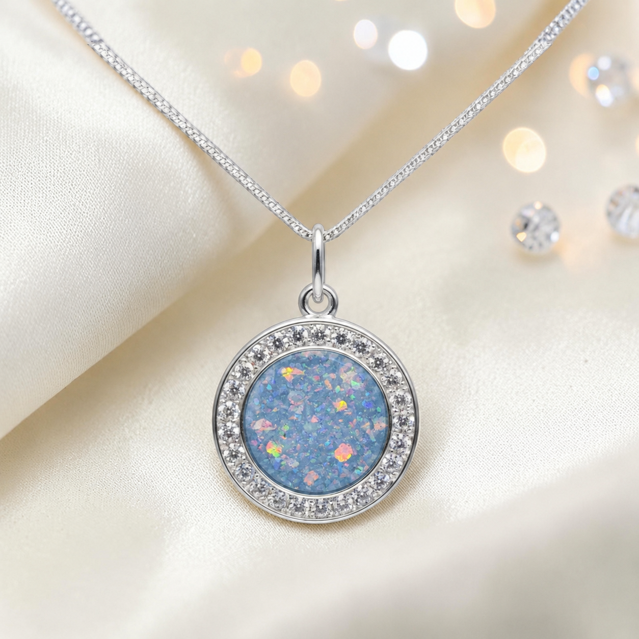 Zosma round memorial locket with CZ stones in baby blue, handcrafted in Lancashire UK  by Keepsake Memorial Jewellery