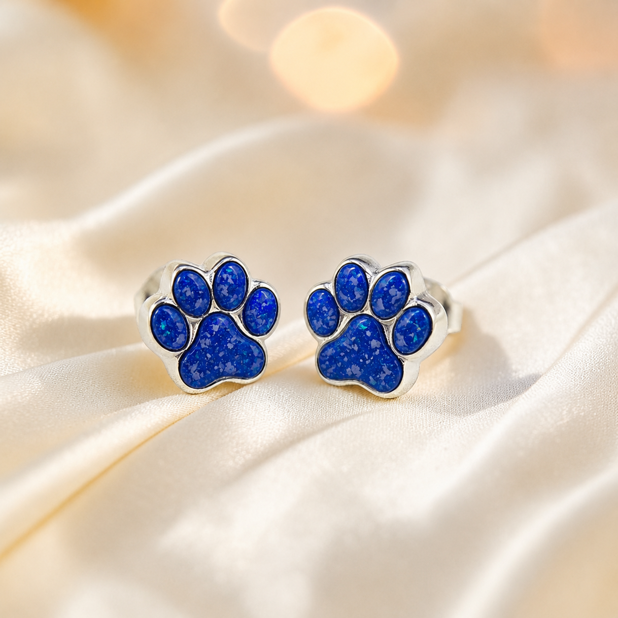 Cleo pet paw memorial ear studs in Royal Blue opal — sterling silver, handcrafted in Lancashire, UK