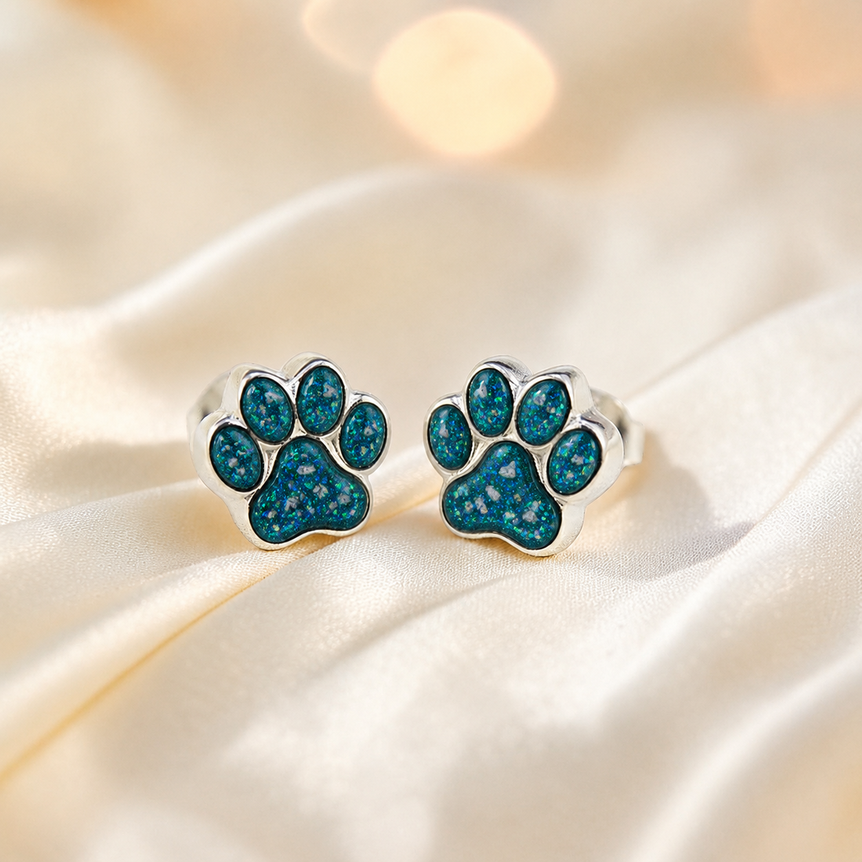 Cleo pet paw memorial ear studs in Teal Mist opal — sterling silver, handcrafted in Lancashire, UK