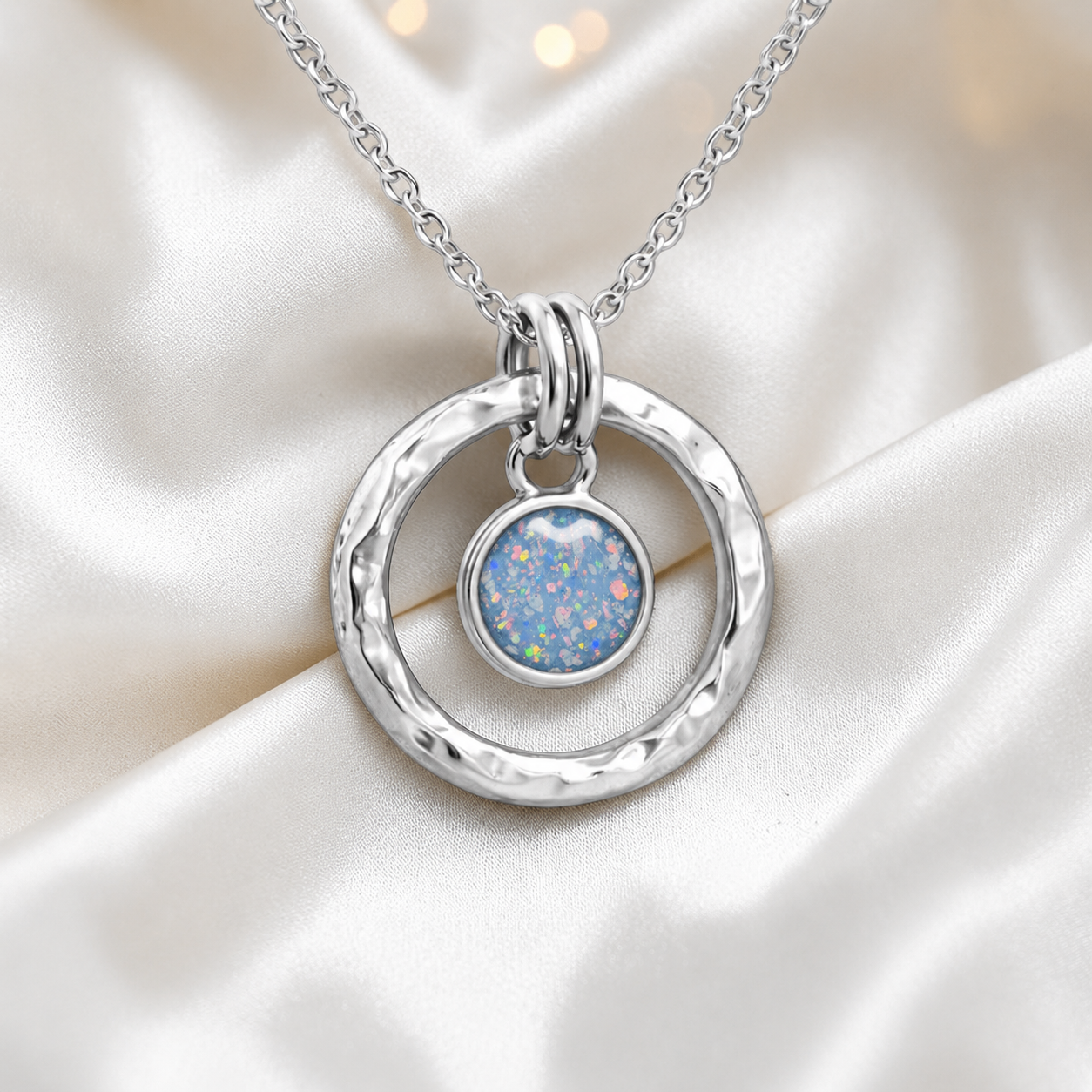 Baby blue hammered hollow circle sterling silver memorial pendant, handcrafted in Lancashire UK by Keepsake Memorial Jewellery
