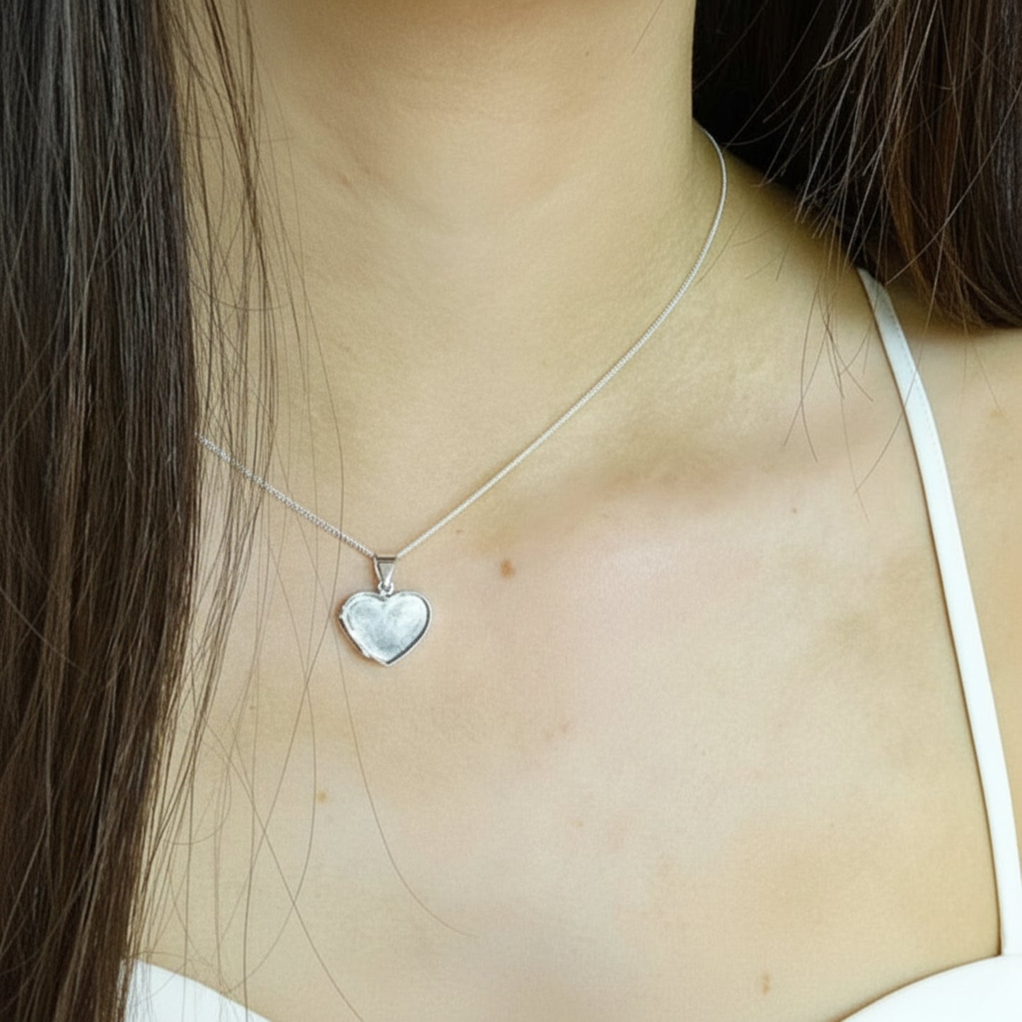 silver heart ashes locket on neck, handcrafted in lancashire