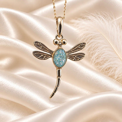 Keepsake Memorial Jewellery gold dragonfly pendant with a shimmering blue inlay on a soft satin background