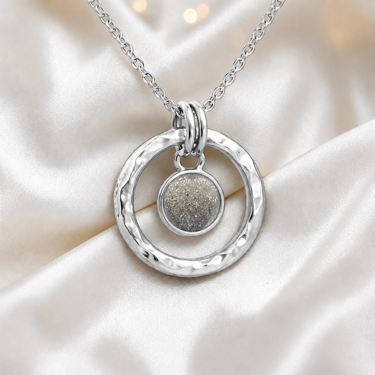 Natural ash hammered hollow circle sterling silver memorial pendant, handcrafted in Lancashire UK by Keepsake Memorial Jewellery

