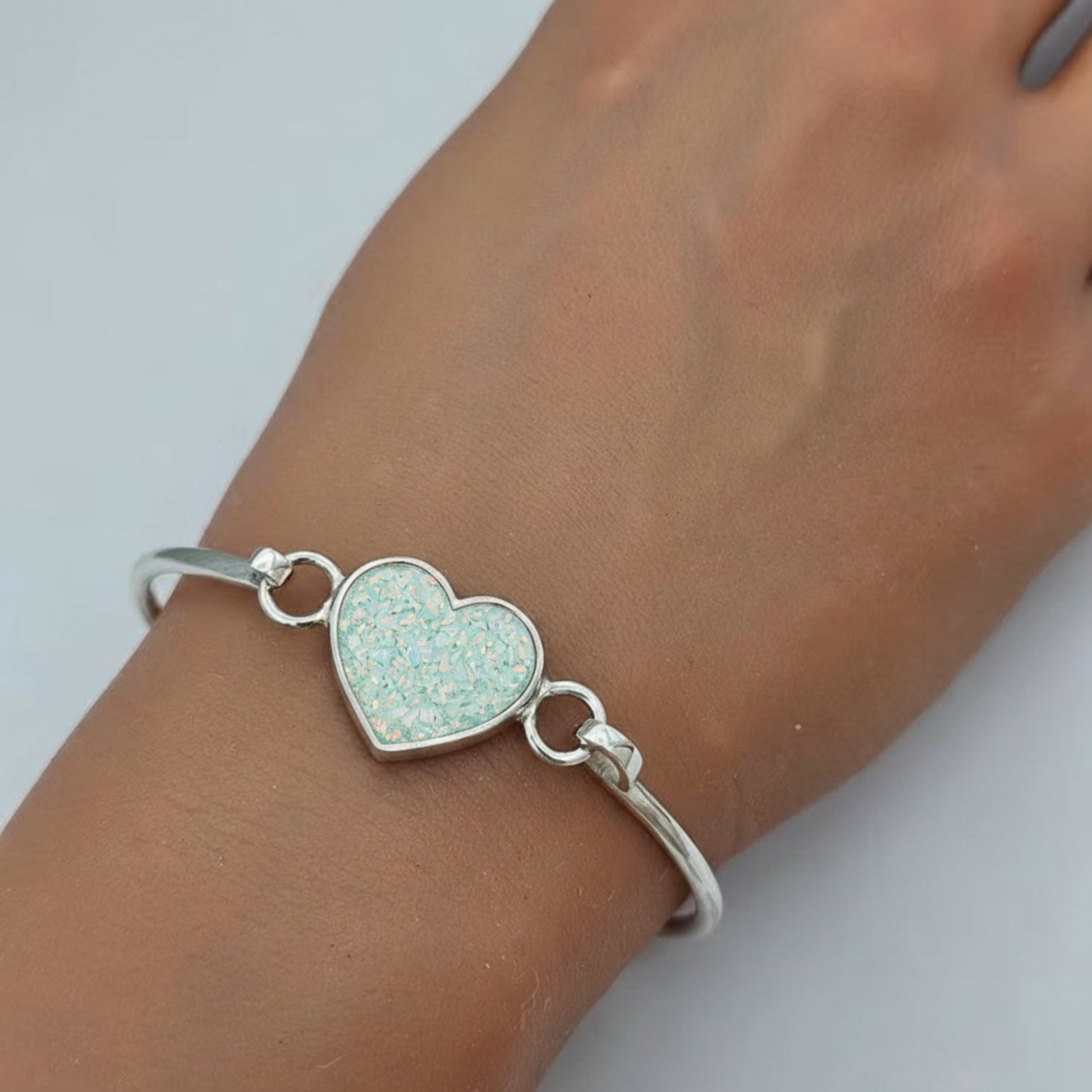 Nyx Bangle — silver ashes memorial bangle with spearmint opal worn on wrist, handcrafted in Lancashire, UK