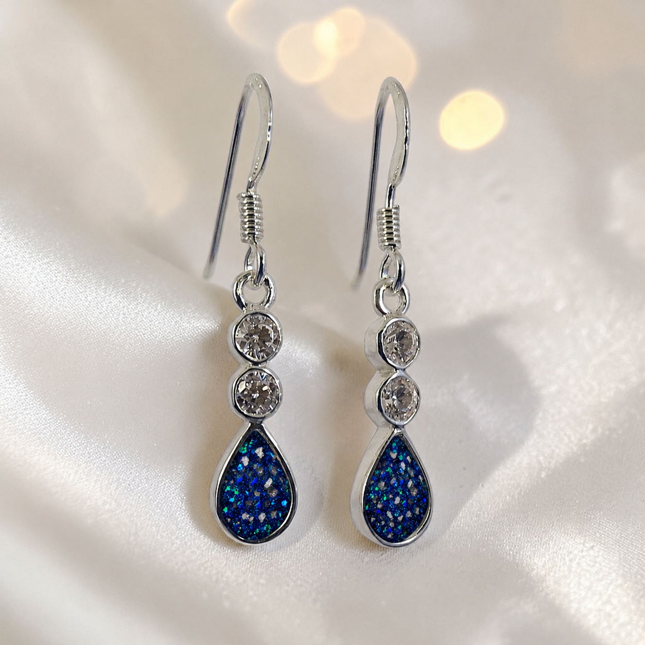 Acrux Earrings — silver pear drop ashes memorial earrings in Sapphire Glow resin, handcrafted in Lancashire, UK