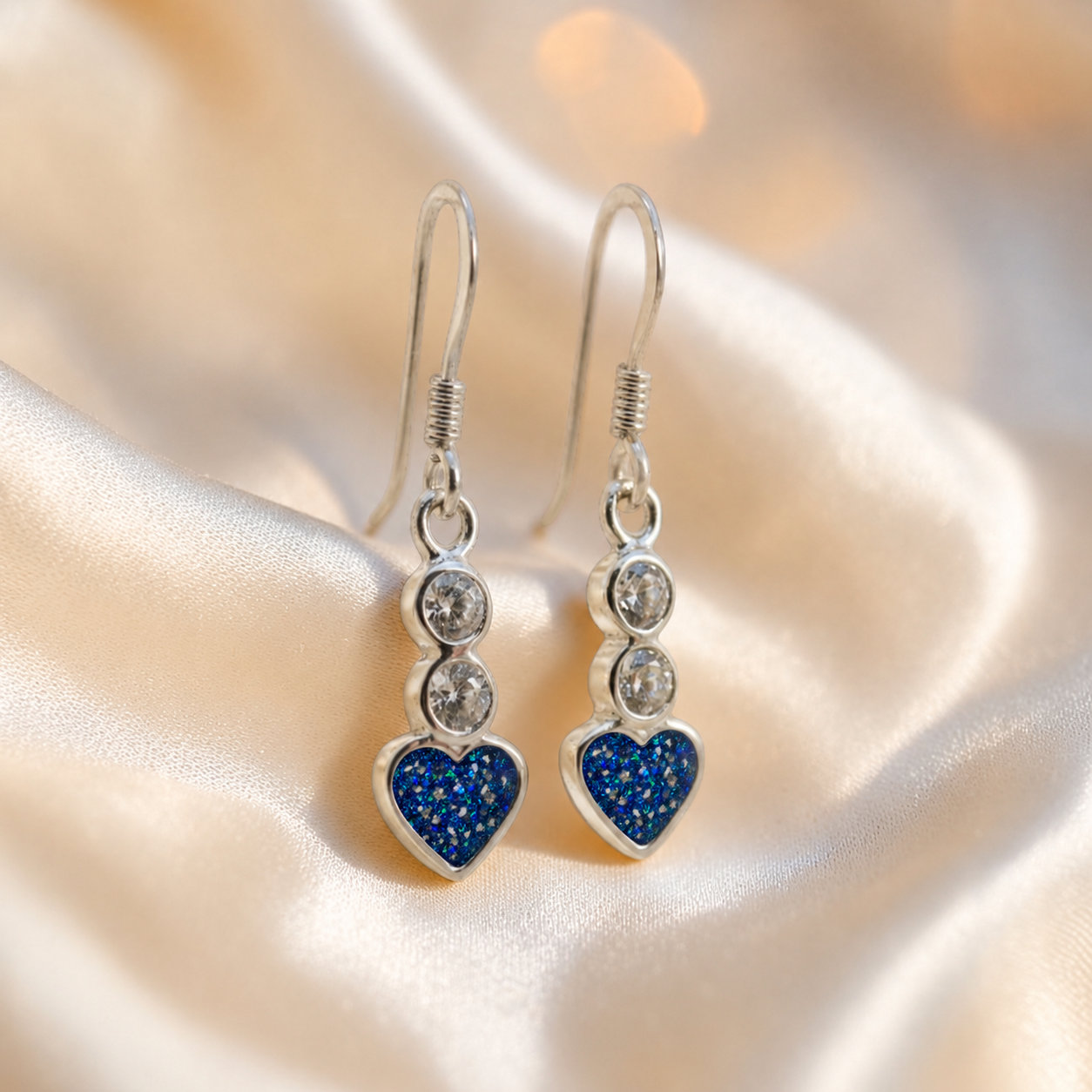 Pleione Earrings — silver heart drop ashes memorial earrings in Sapphire Glow resin, handcrafted in Lancashire, UK
