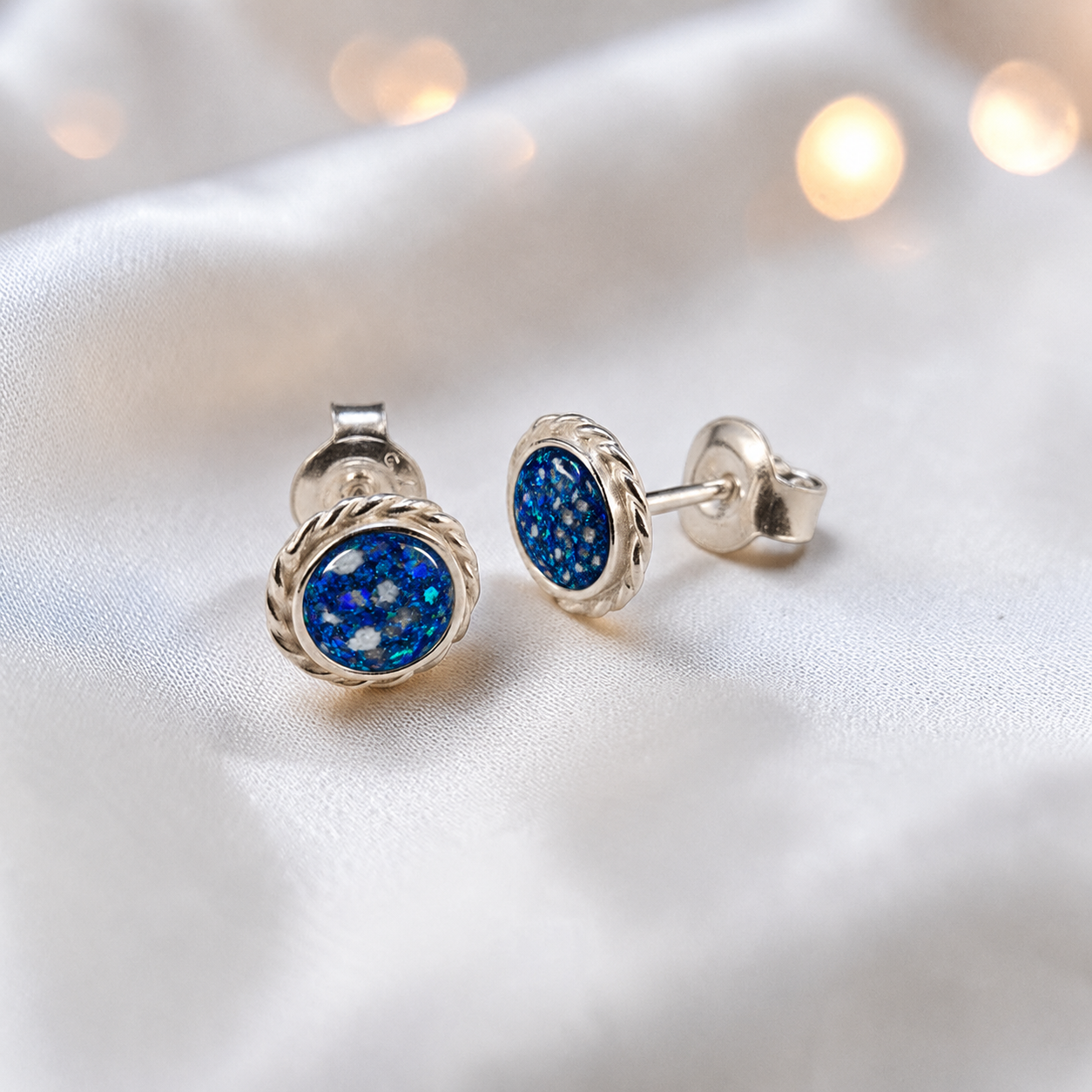 Eterna memorial stud earrings in Sapphire Glow opal — sterling silver rope edge, handcrafted in Lancashire, UK