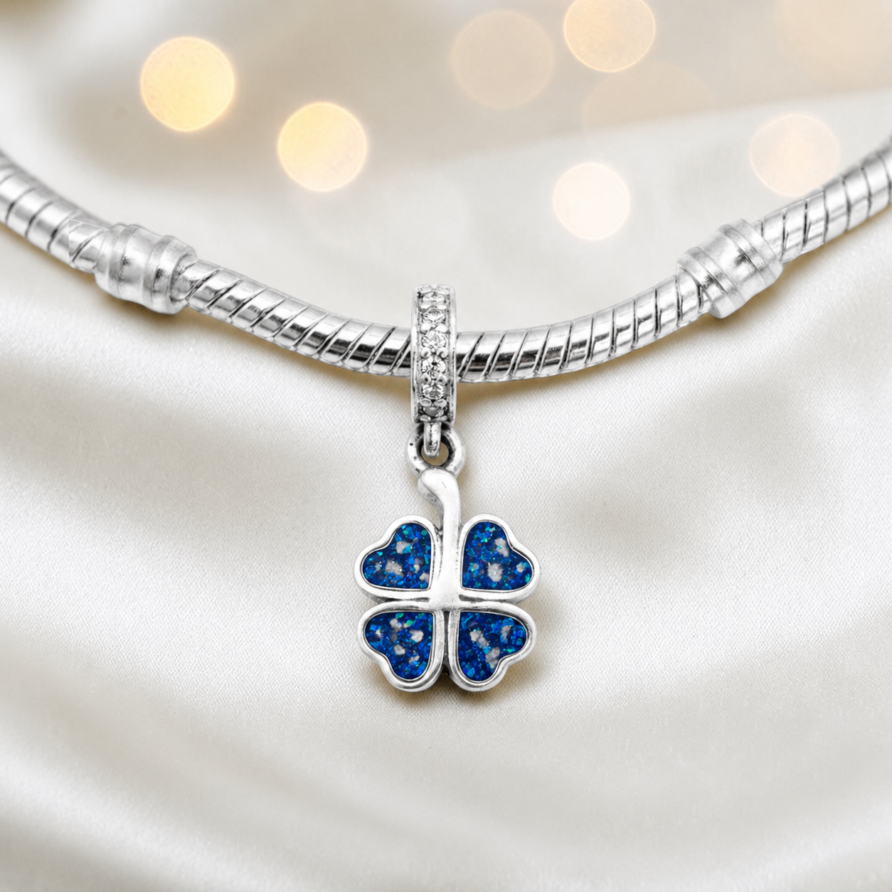 Sapphire glow sterling silver clover dangle ashes memorial charm, handcrafted in Lancashire by keepsake memorial