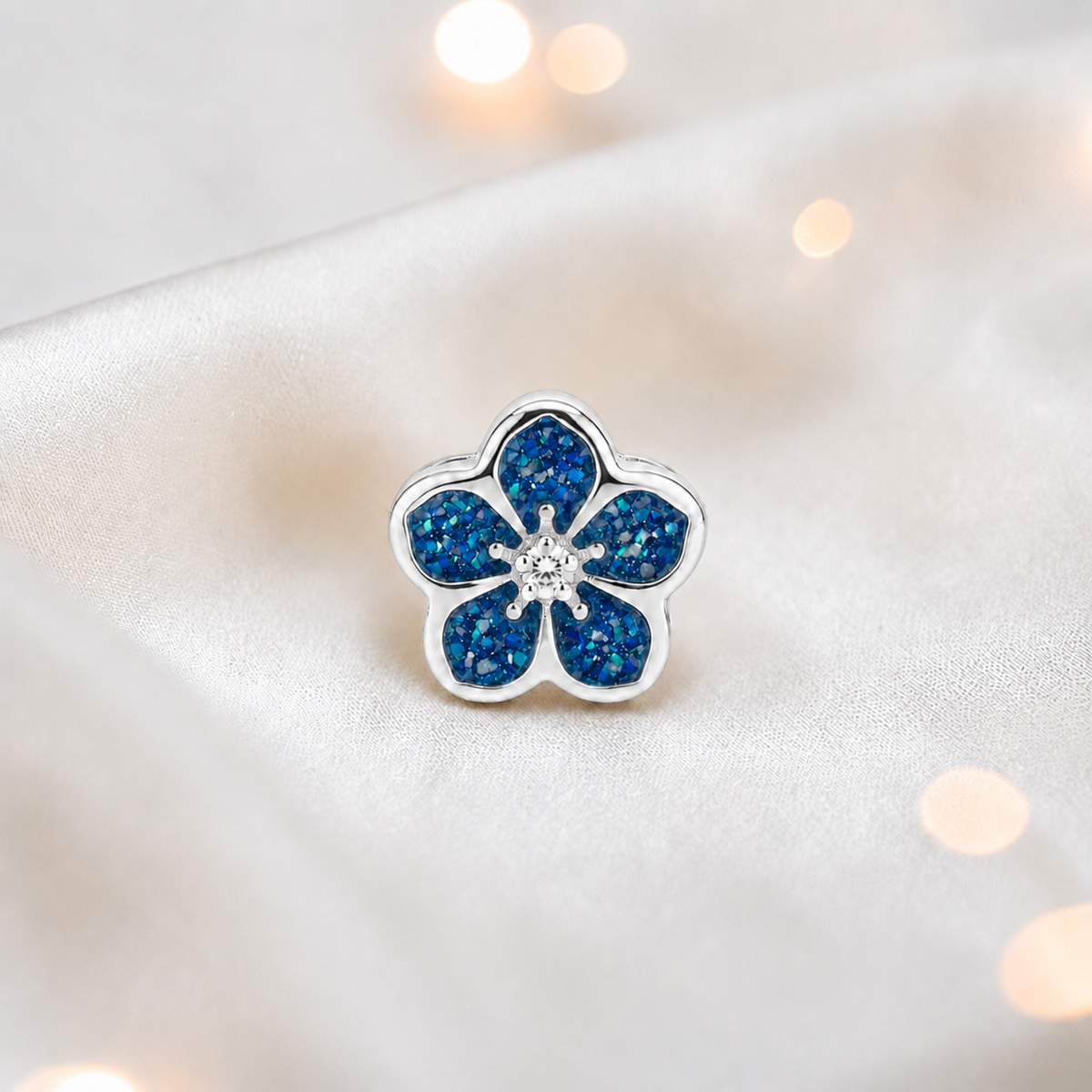 Sapphire glow sterling silver forget me not ashes memorial charm, handcrafted in Lancashire by keepsake memorial