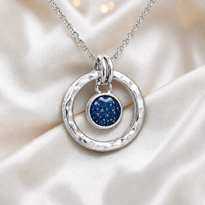 Sapphire blue hammered hollow circle sterling silver memorial pendant, handcrafted in Lancashire UK by Keepsake Memorial Jewellery
