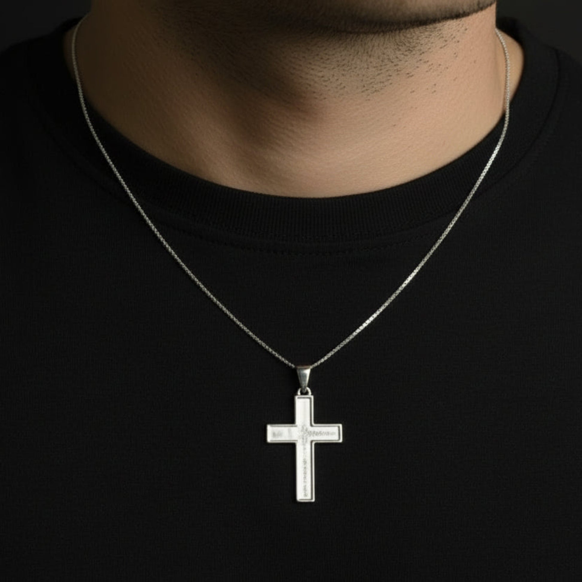 silver cross on mans neck