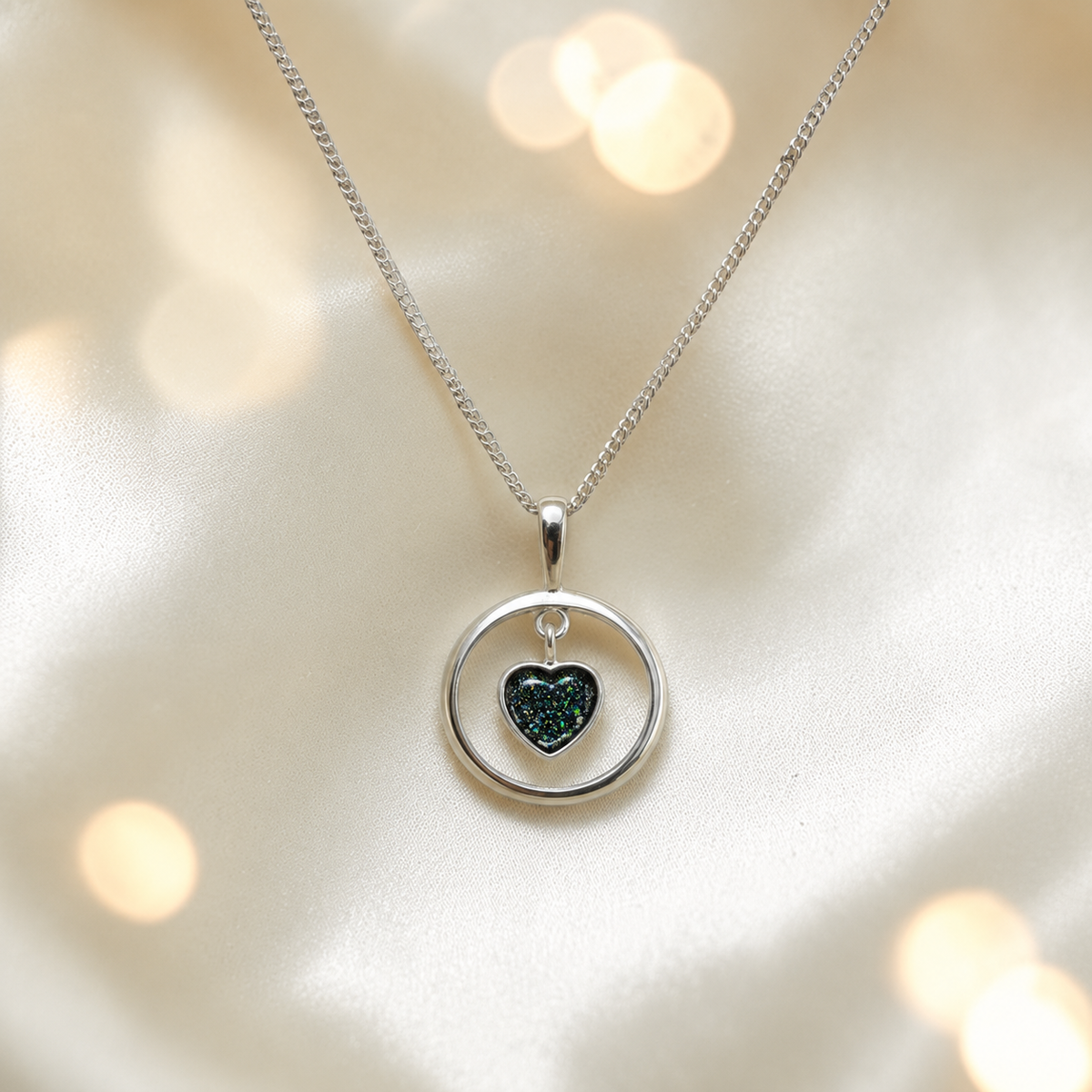 Wren silver open circle with heart drop ashes pendant in black flame, handcrafted in Lancashire UK