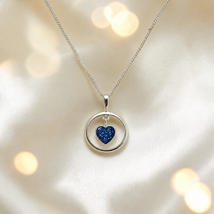 Wren silver open circle with heart drop ashes pendant in sapphire glow, handcrafted in Lancashire UK